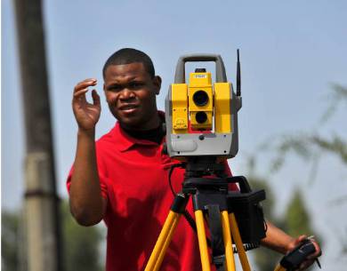 a man of color using a theodolite performing a wall check survey