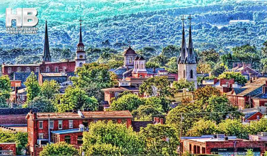 a painting of the frederick, maryland skyline, it's very pleasing to the eye, the hills in the background all have a frost covering but down in the town the trees are green and the colors are vibrant.