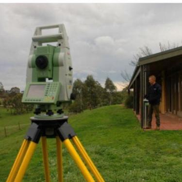 an image of a home looking down the front side with a theodolite in the foreground looking down the same.